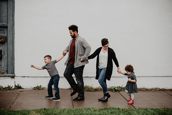 a young family walks together hand in hand